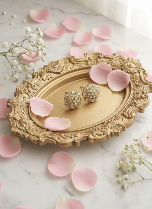 Gold floral earrings on baroque tray