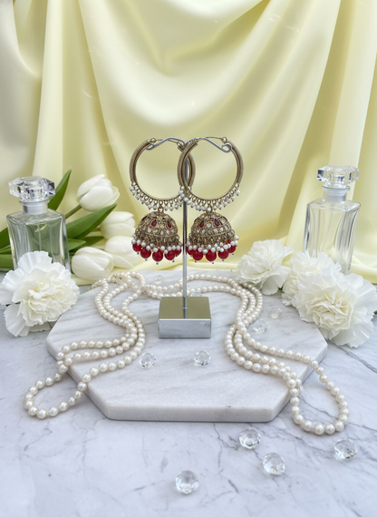 Red kundan bali earrings on pastel yellow