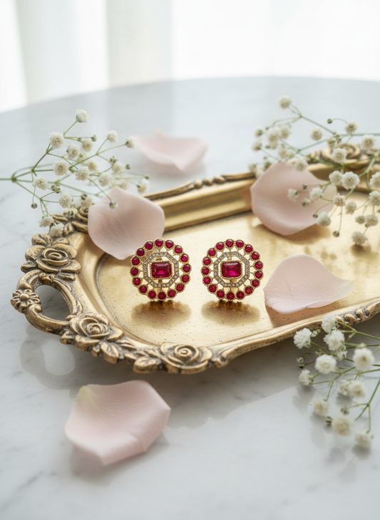 Ruby and gold studs on gold jewelry tray